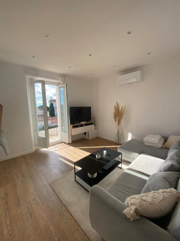 un salon avec un canapé et une table dans l'établissement T2 neuf avec vue mer à 2 pas du centre et proche des plages, à Bandol