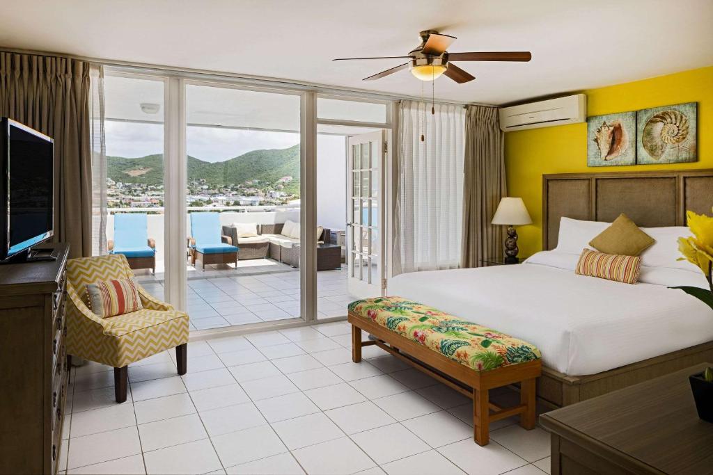 シンプソン・ベイにあるThe Atrium Beach Resort and Spa, Ascend Hotel Collectionのベッドルーム(ベッド1台、テレビ、バルコニー付)