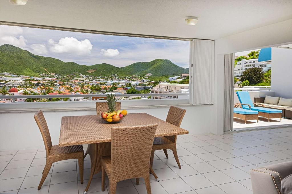 シンプソン・ベイにあるThe Atrium Beach Resort and Spa, Ascend Hotel Collectionのテーブルと椅子と大きな窓のあるダイニングルーム