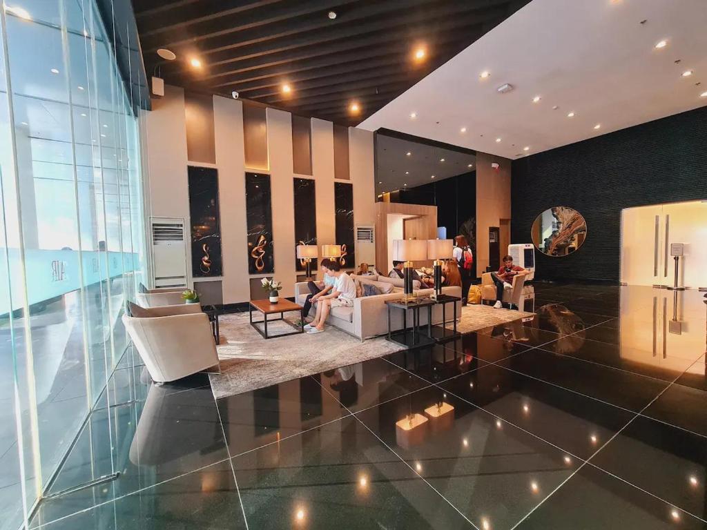 a lobby with people sitting on couches in a building at Makati Ayala luxury Stylish Uncle Sam condo Gym Swim Park 300 Mb 2641 in Manila
