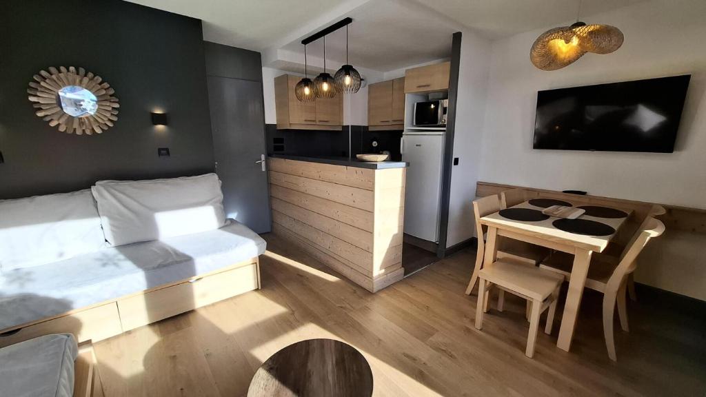 une chambre avec un lit et une table et une cuisine dans l'établissement Résidence Ellebore - Appartement cosy et lumineux coeur de station MAE-5791, à Aime La Plagne