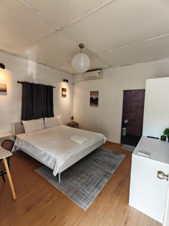 une chambre avec un lit blanc dans une pièce dans l'établissement MaMa Resort Thongsala Koh Phangan, à Thongsala
