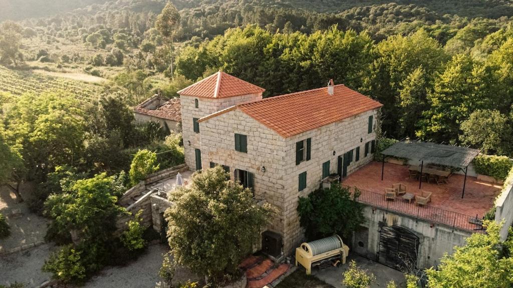 une vue aérienne d'une maison avec un camion devant elle dans l'établissement Le chai, belle villa pour 13 personnes au coeur d'un vignoble avec piscine, à Sartène
