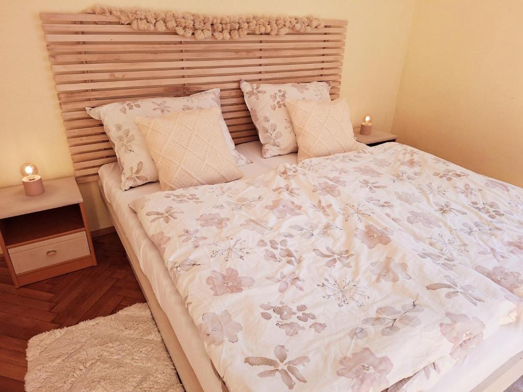 Un dormitorio con una cama grande con cabecero de madera. en Middletown apartment No 1, self check-in 24 h, en Banská Bystrica