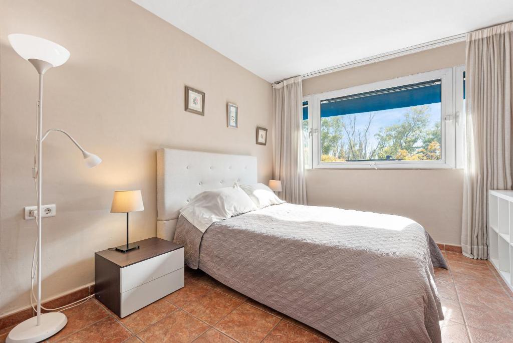 ein Schlafzimmer mit einem Bett und einem Fenster in der Unterkunft Acogedor estudio en Pedregalejo junto al mar in Málaga