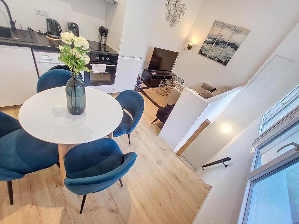 une salle à manger avec une table et des chaises bleues dans l'établissement Confort Climatisé et Suite Privée en Sousplex, à Montpellier