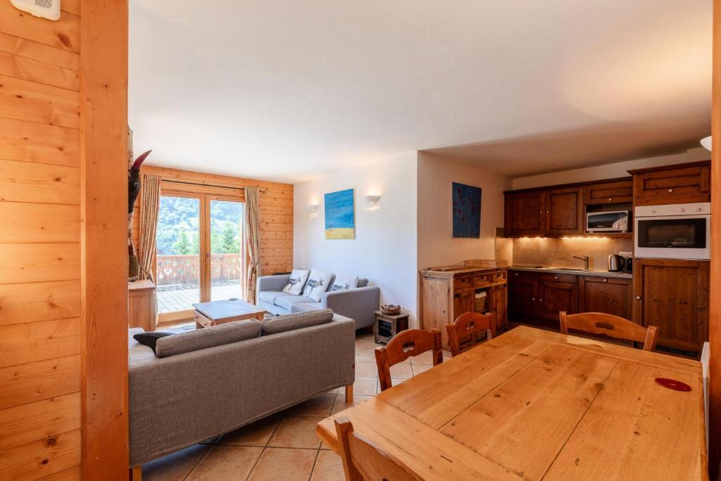 uma sala de estar com um sofá e uma mesa em Résidence Bergerie Des 3 Vallees F - Appartement 4 pièces 6 personnes situé dans le charmant village des allues MAE-4991 em Les Allues