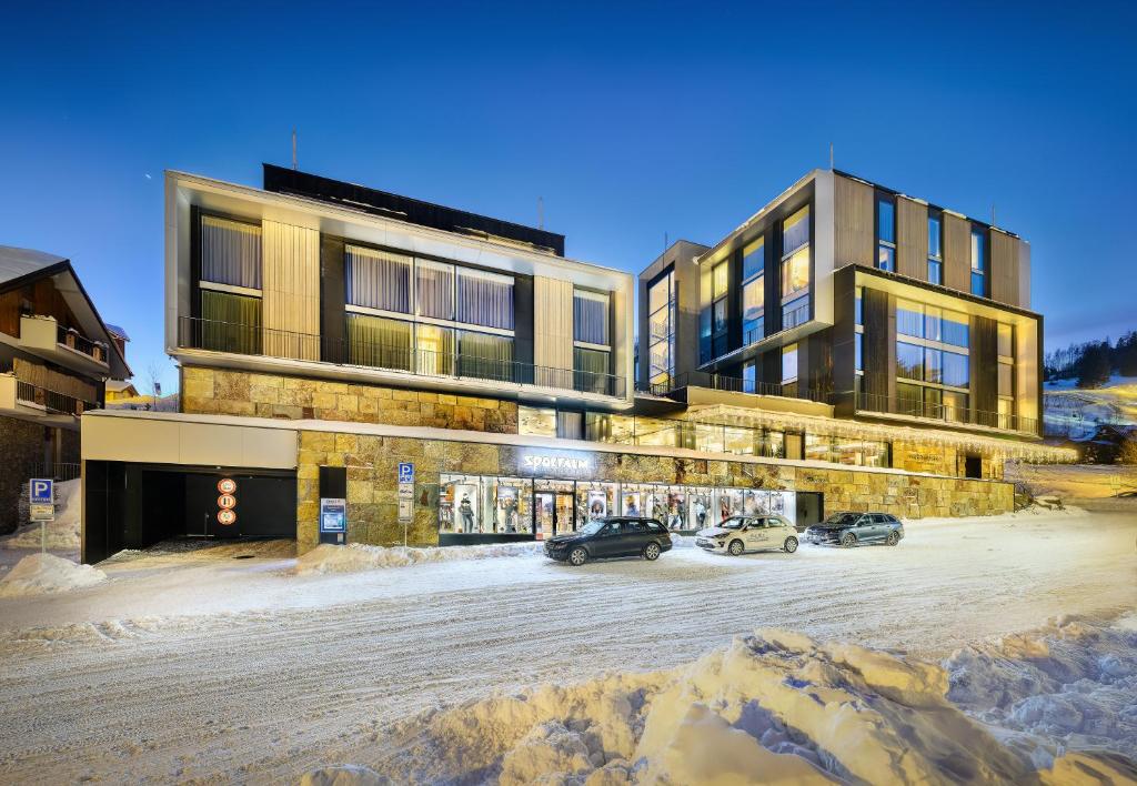 a building with cars parked in a parking lot at Grand Hotel Hradec in Pec pod Sněžkou