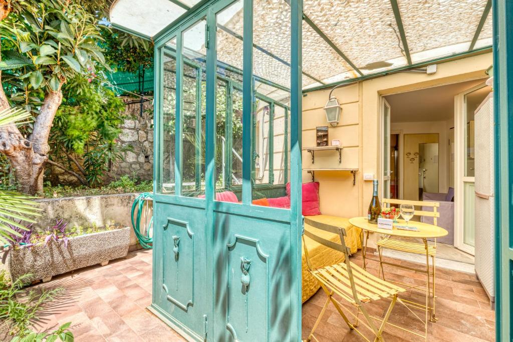 une serre avec une table dans le patio dans l'établissement Nice Studio With Garden - Happy Rentals, à Menton
