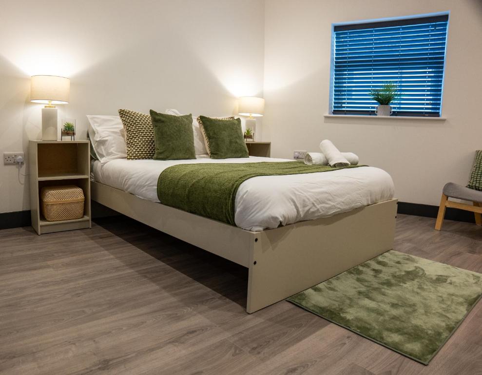 Un dormitorio con una cama grande con una manta verde. en Ilkeston High End Apartments Perfect For Contractors, en Ilkeston