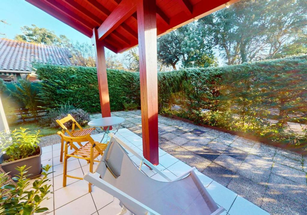 - un kiosque avec une table et des chaises sur la terrasse dans l'établissement LES ESTIVALES - Maison mitoyenne pour 4 personnes, à Capbreton