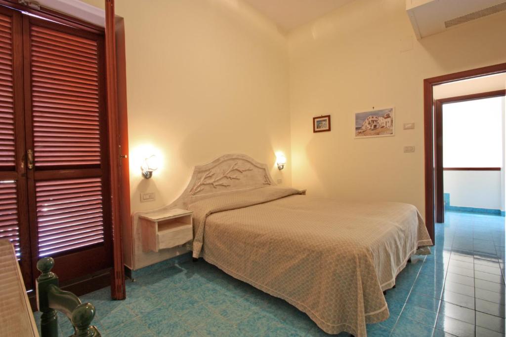 a small bedroom with a bed and a window at Hotel La Certosa in Massa Lubrense