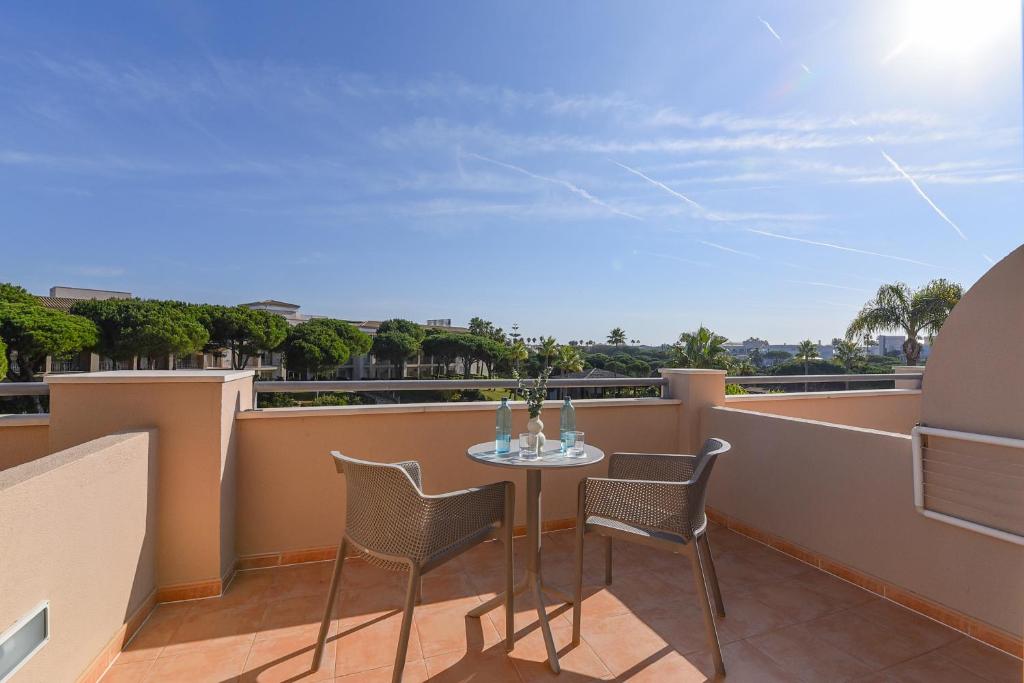 a patio with a table and chairs on a balcony at Valentin Sancti Petri in Chiclana de la Frontera
