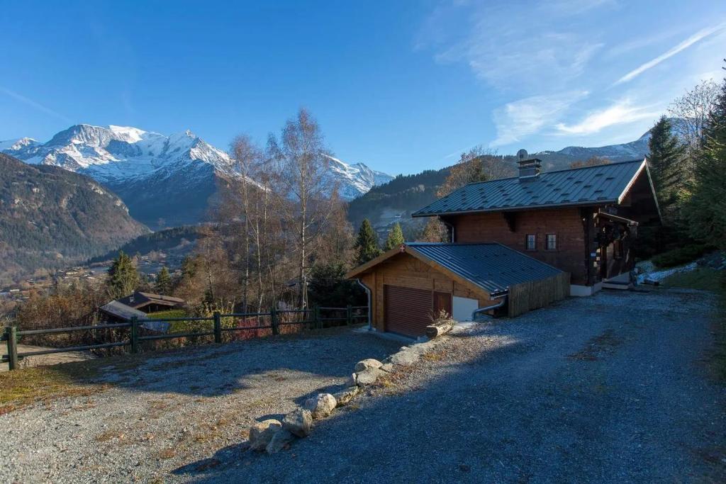 un bâtiment avec une clôture à côté d'une montagne dans l'établissement Chalet spacieux à Saint-Gervais-les-Bains avec vue montagne, à Saint-Gervais-les-Bains
