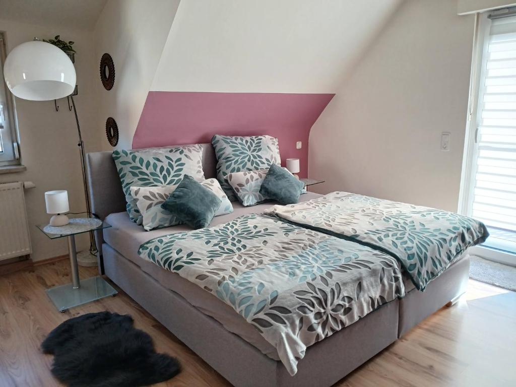 a bedroom with a bed and a pink wall at Ferienwohnung Vögnitz in Sulzheim
