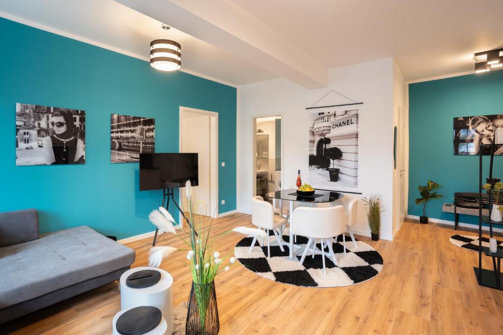 a living room with blue walls and a table and chairs at ANER 4 Design Apartment Zoe in Dresden