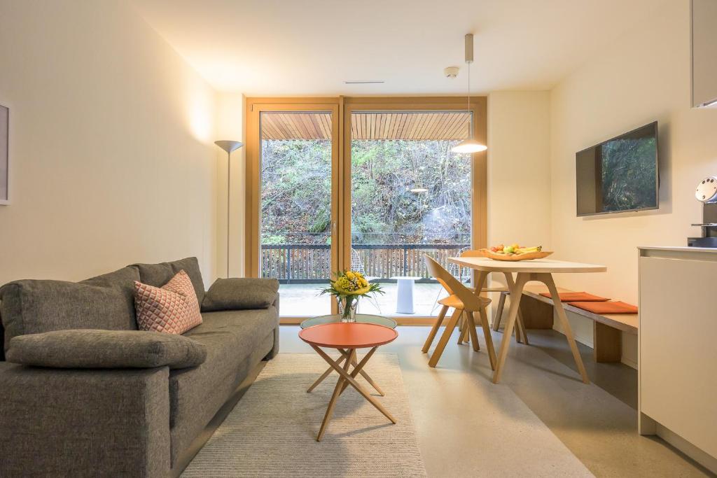 a living room with a couch and a table at Edelweiss Ferienwohnung, Stenna Flims in Flims