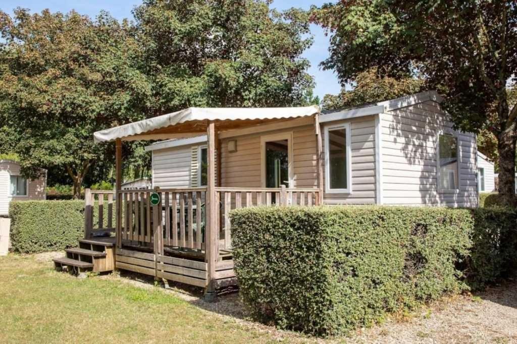 Cabaña de madera pequeña con porche en un patio en Camping 4 étoiles - ccaeh0a, en Châlons-en-Champagne