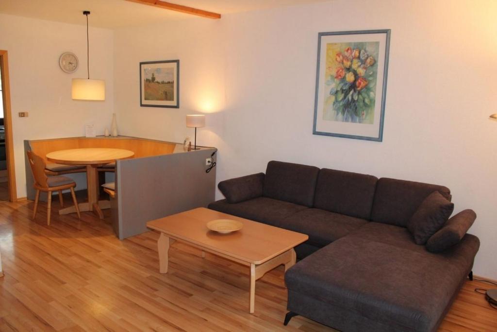 a living room with a couch and a table at Ferienhaus Nr 5, Kategorie Komfort, Feriendorf Hochbergle, Allgäu in Lechbruck
