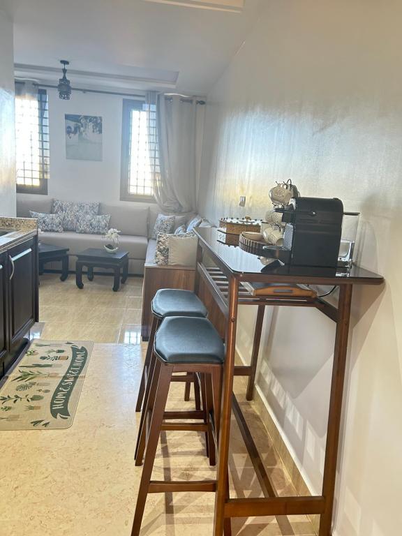 ein Wohnzimmer mit einem Tisch und einem Laptop darauf in der Unterkunft Harmonie d Agdal Marrakech avec Piscine in Marrakesch