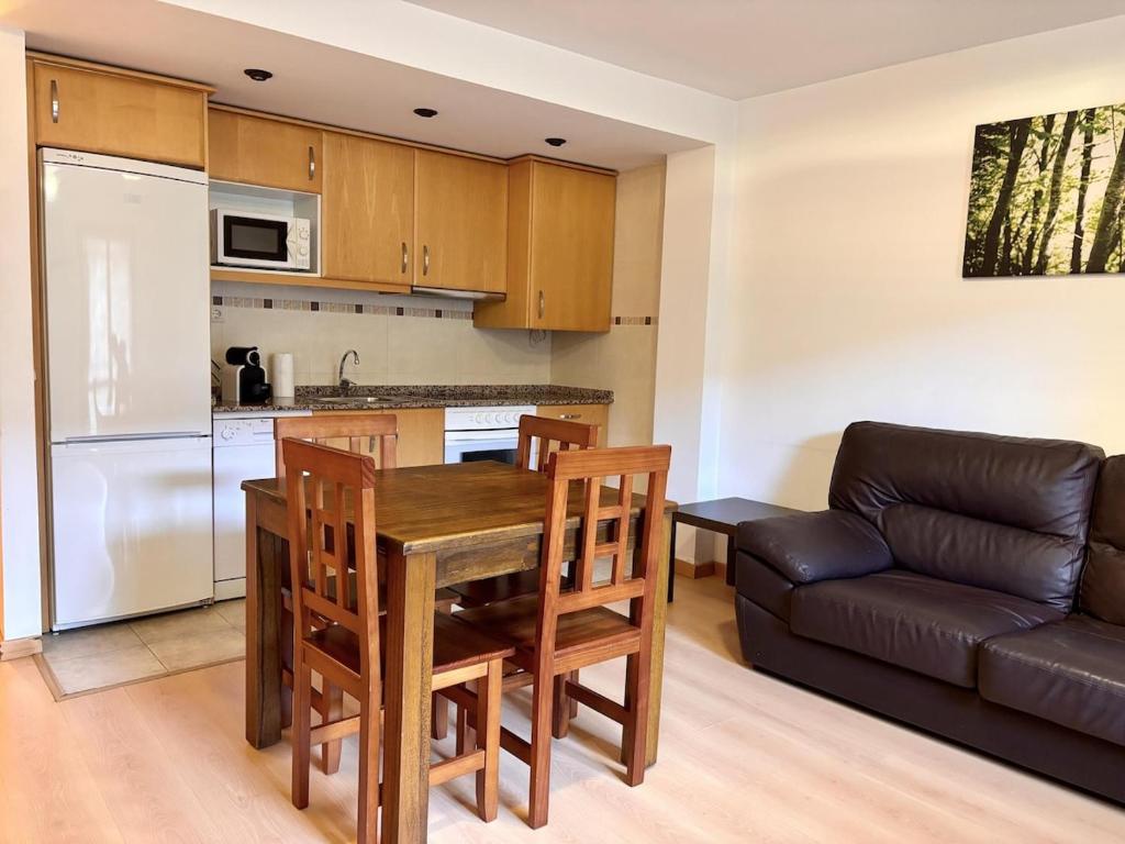 a kitchen and living room with a table and a couch at BPirineos-Casa Chuanina in Benasque
