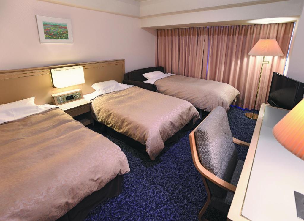 Postel nebo postele na pokoji v ubytování Bandai Silver Hotel