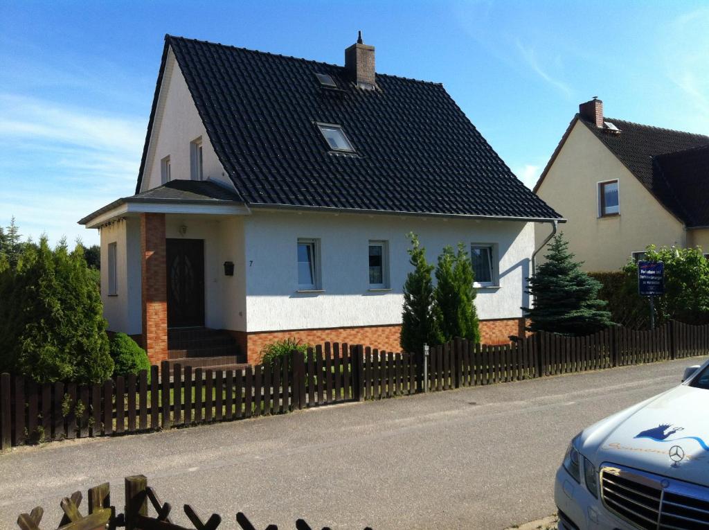 a white house with a black roof at Ferienhäuser Wede in Ueckeritz