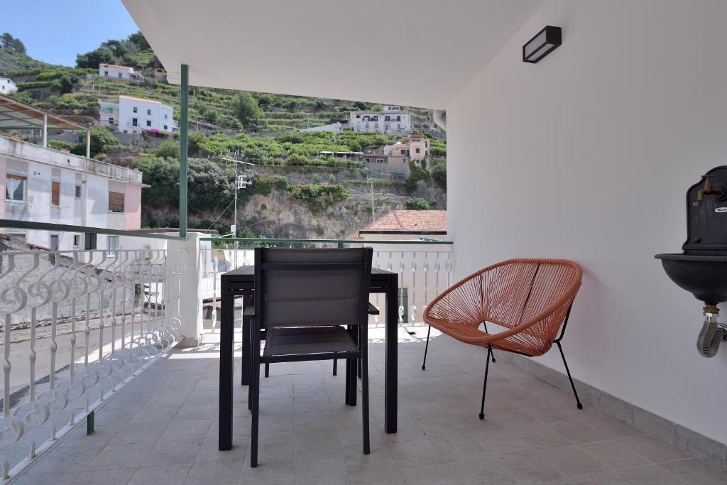 a black table and two chairs on a balcony at L' Orologio del Campanile with terrace in Minori