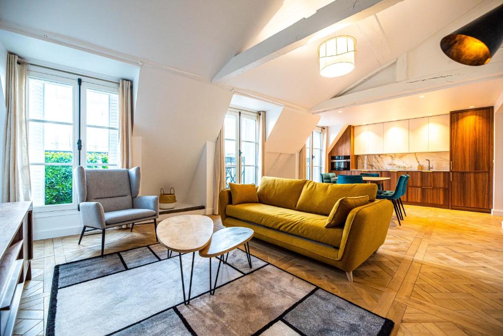 un salon avec un canapé et une table dans l'établissement CIA - flat in Paris Louvre museum with balcony, à Paris
