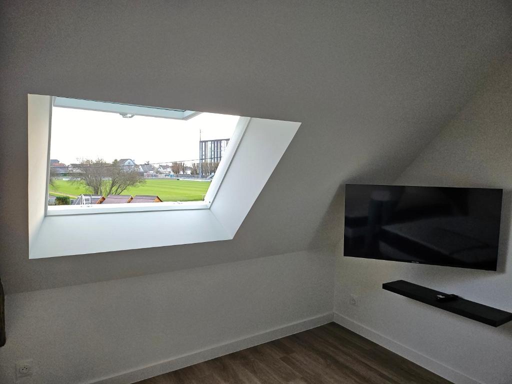 a room with a flat screen tv and a window at Appartement Granville 5 in Granville