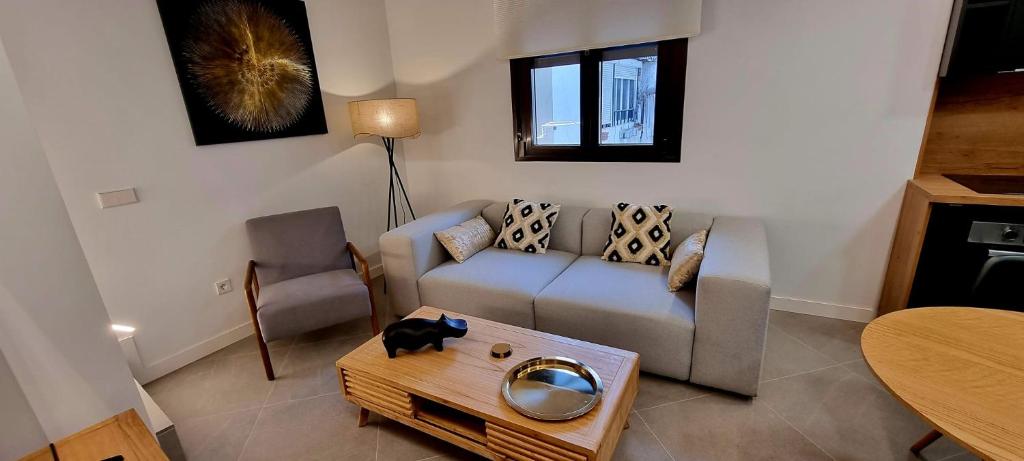 a living room with a couch and a table at Apartamentos El Dedal de Alcalá in Alcalá de Henares