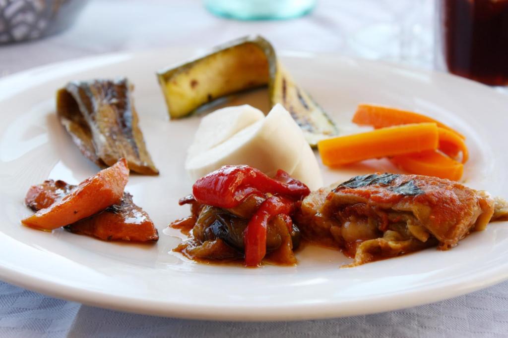 a plate of food with meat and vegetables on a table at Hotel La Certosa in Massa Lubrense