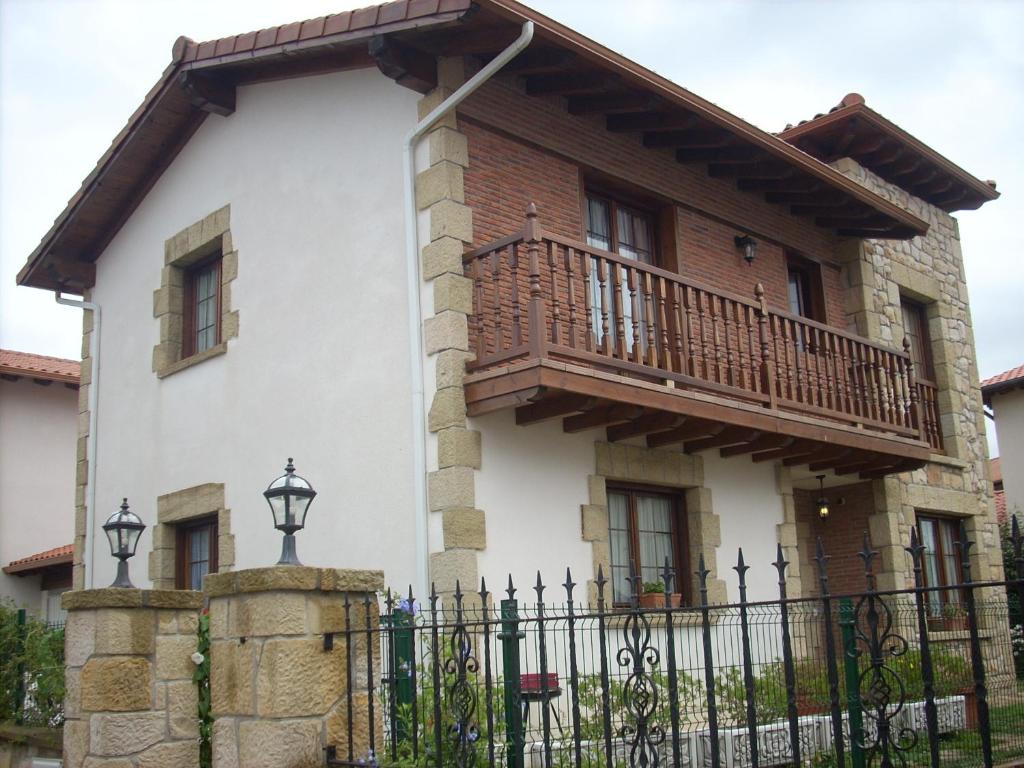 a house with a balcony and a fence at Casa Rio Cubas in Cubas