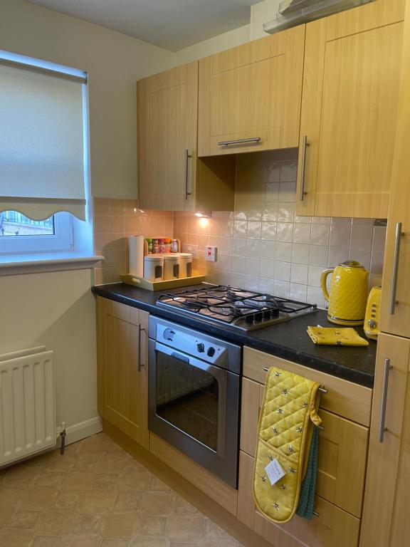een keuken met een fornuis en een fornuis bovenste oven bij Workers 3 bedroom beach boulevard apt in Aberdeen