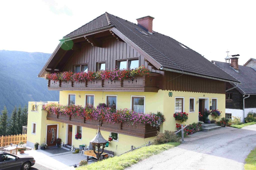 ein Haus mit Blumen auf der Seite in der Unterkunft Binderhof in Weisspriach