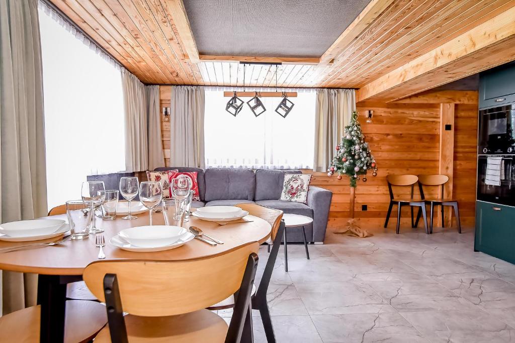 a dining room with a table and a couch at Apartament Hanka z Jacuzzi i widokiem na góry in Zakopane