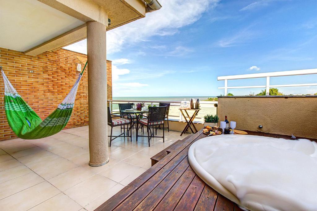 a hammock on a balcony with a view of the ocean at Breezes do cumbuco in Caucaia