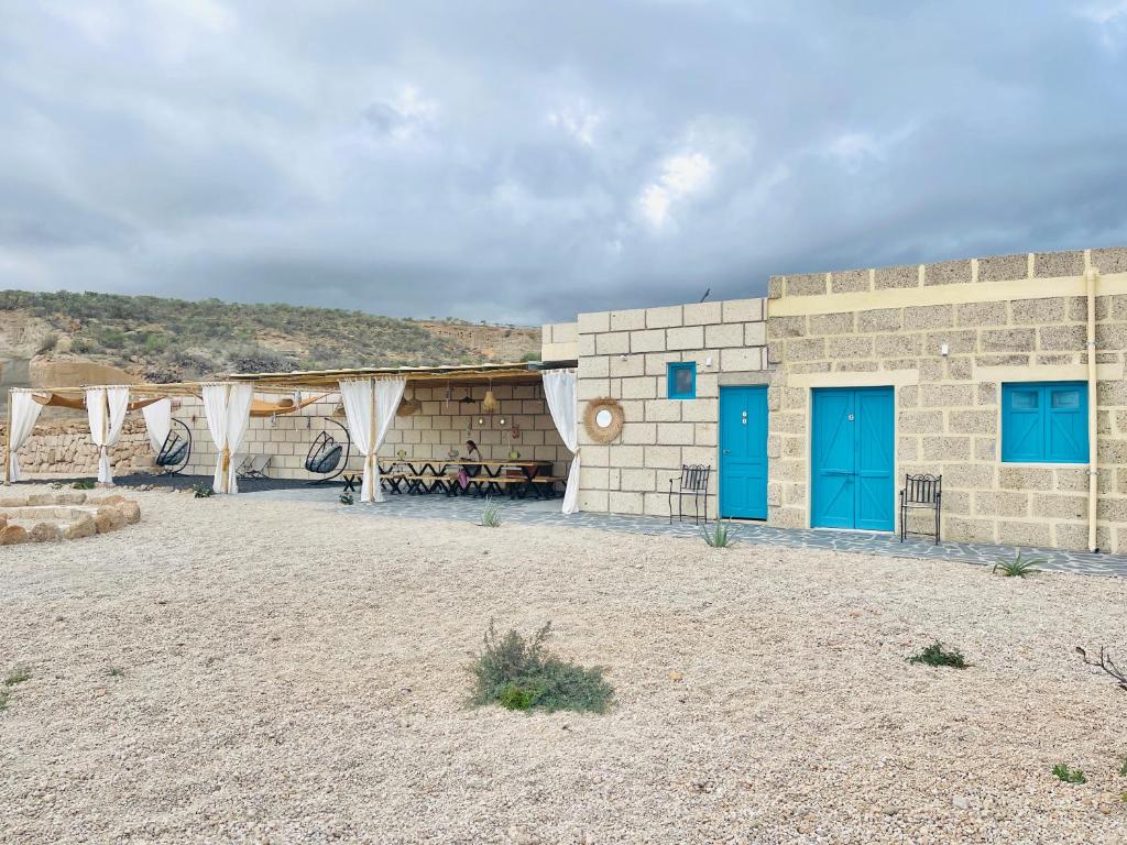 a brick building with blue doors in a desert at Las Cuevas - 3 bed finca in a serene setting in Santa Cruz de Tenerife