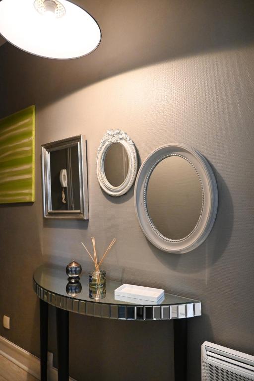 une table avec deux miroirs sur un mur dans l'établissement LE COSY 73 - Proche plage et port de Granville, à Granville