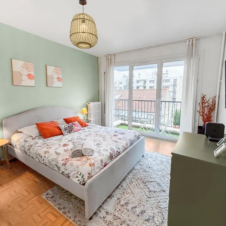 une chambre avec un lit et une grande fenêtre dans l'établissement Balcon Cosy près de la Marne, à Saint-Maur-des-Fossés