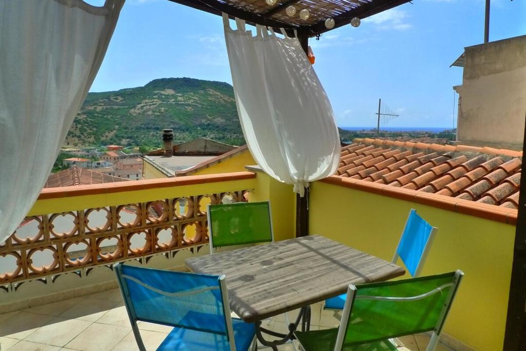 a table and chairs on a balcony with a view at Casa Vista Mare in Bosa