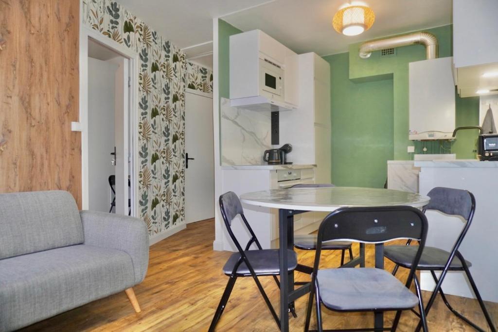 - une cuisine et une table avec des chaises dans la chambre dans l'établissement Le FOCH, appartement 3 chambres - proche Nancy Thermal, à Villers-lès-Nancy