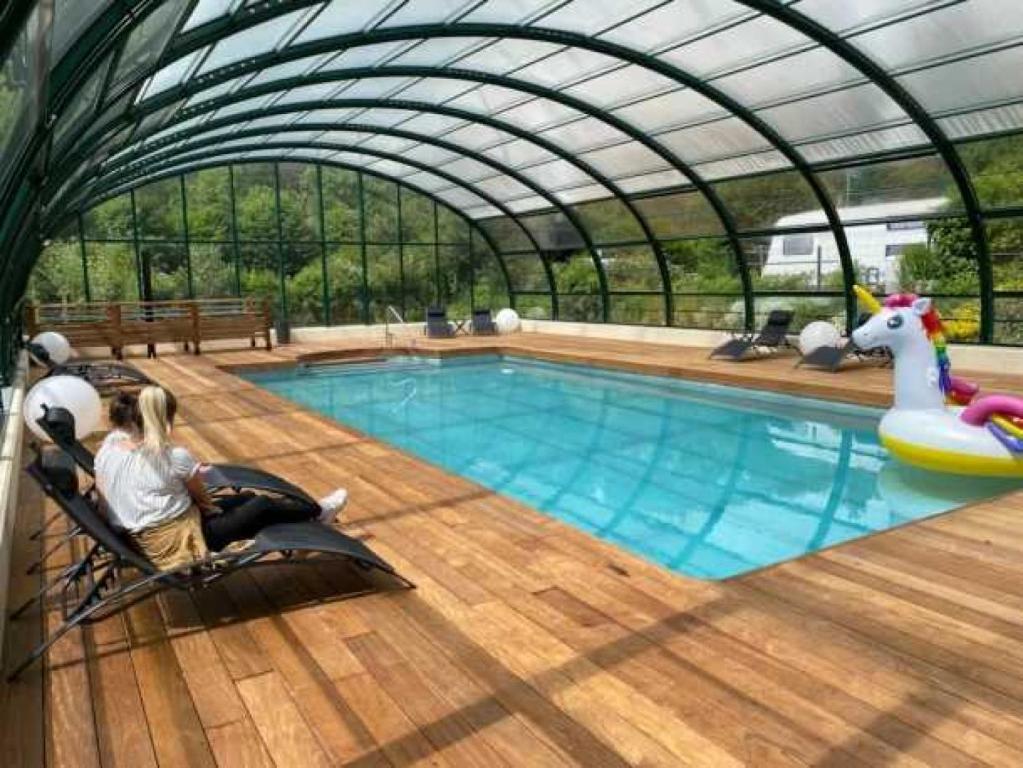 een groot zwembad met een zwemnoodle in een gebouw bij Camping 3 étoiles - Piscine - eehhec in Landry