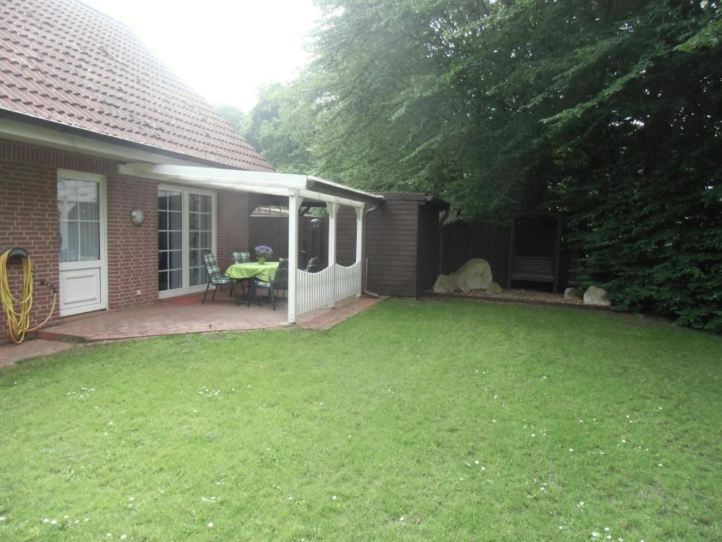 einen Hinterhof eines Hauses mit einem Rasenplatz in der Unterkunft Busche RE03 in Sögel