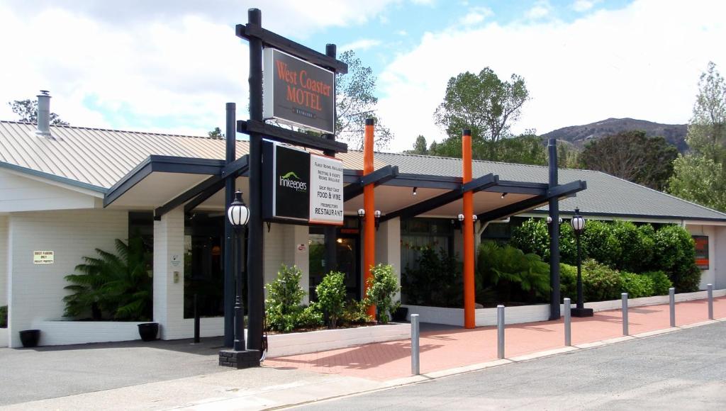 een gebouw met een bord ervoor bij West Coaster Motel in Queenstown