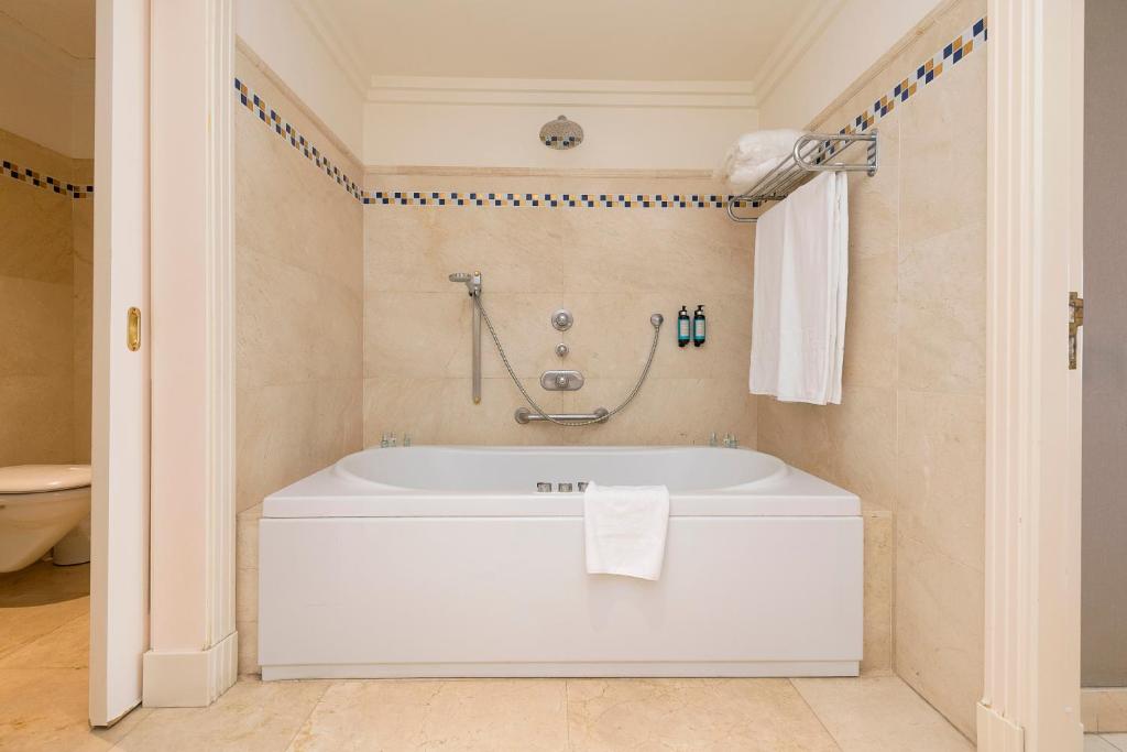a bathroom with a white tub in a room at Hotel Playa Victoria in Cádiz