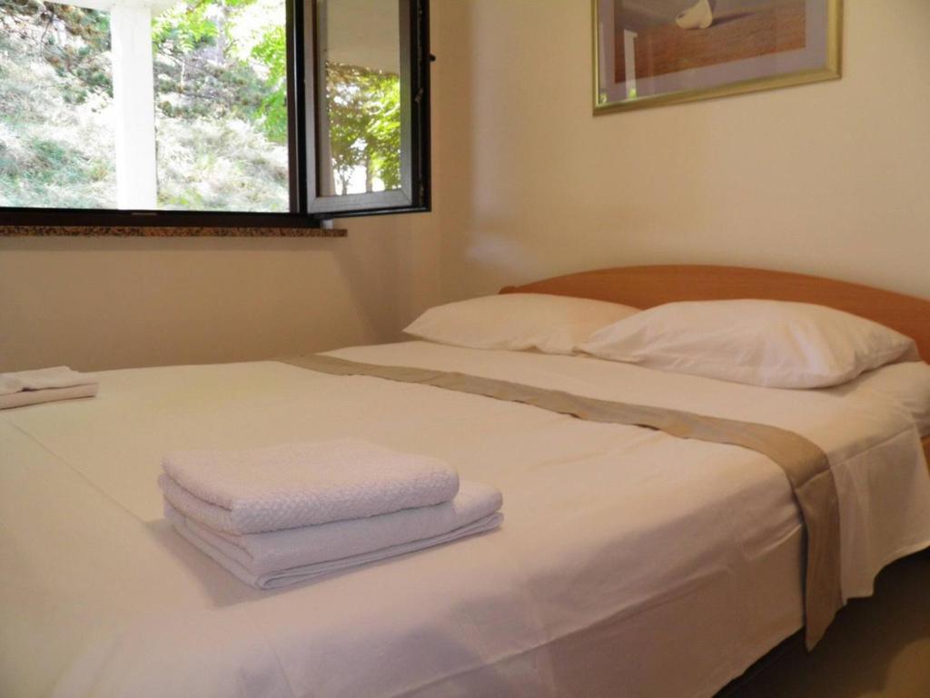 łóżko z dwoma ręcznikami i oknem w obiekcie Apartment Starcevic Filipovic w Bašce