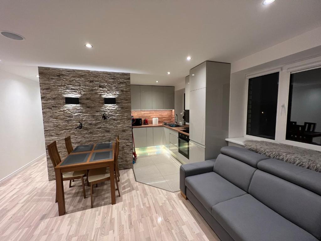 a living room with a couch and a table and a kitchen at Luxurious stay at modern apartment (Cesis) in Cēsis
