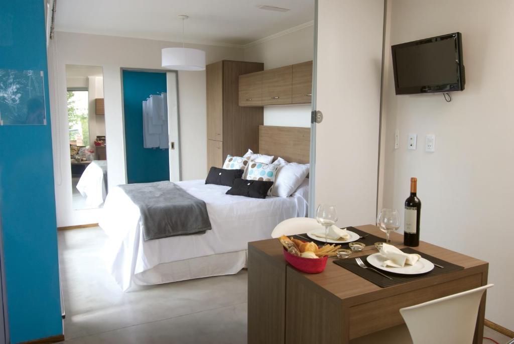 カンパーナにあるRefugio Urbano Apartamentosのベッドルーム1室(ベッド1台、テーブル、食べ物1杯付)