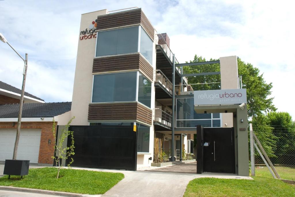 een gebouw met een bord waarop staat: Enjoy Uber bij Refugio Urbano Apartamentos in Campana